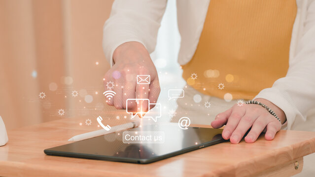 Contact us or dial our customer service number. A businesswoman touching the virtual contact symbols on his laptop's screen ( email, address, live chat, internet wifi ).