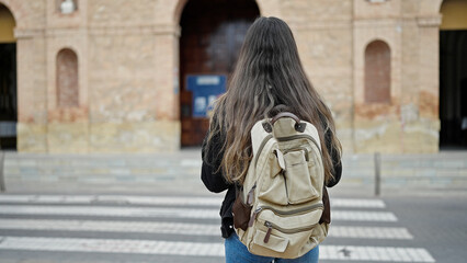 Fototapeta na wymiar Young beautiful hispanic woman student standing on back view at street