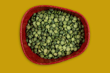 green peas in halves in bowl isolated on background. Top view. Flat lay