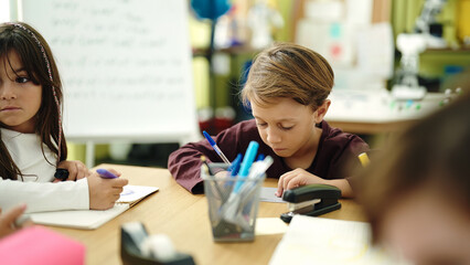 Group of kids students sitting on table studying at classroom