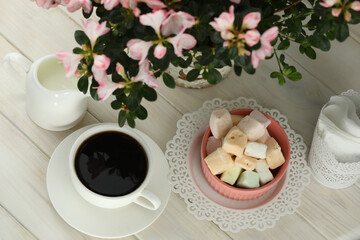 cup of coffee with marshmallow on white wooden table