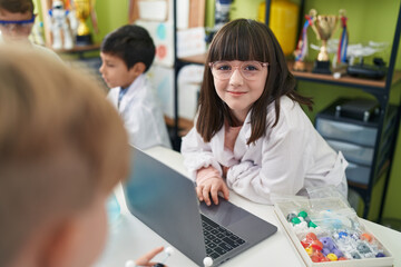 Adorable boy and girl scientist student using laptop at laboratory classroom
