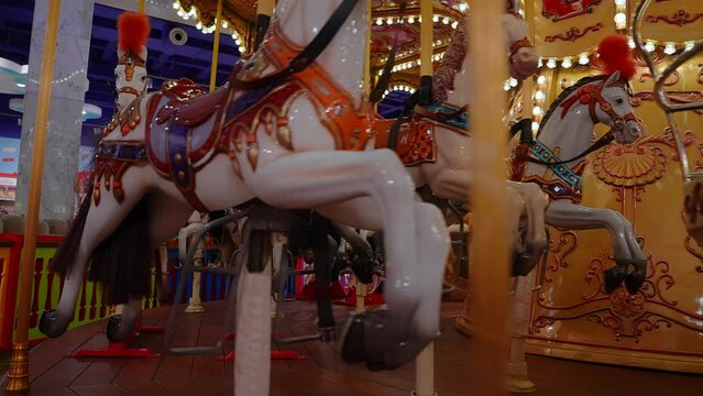 Old French carousel in a holiday park. Three horses and airplane on a traditional fairground vintage carousel. Merry-go-round with horses.