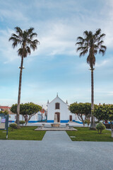 Fototapeta na wymiar Beauty of the architecture and the church in Porto Covo in the typical white and blue colours of the local square. A village in western Portugal
