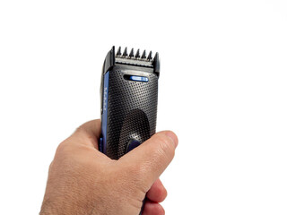 Hair clipper in hand isolated on white background. Modern hair clipper. Close-up.