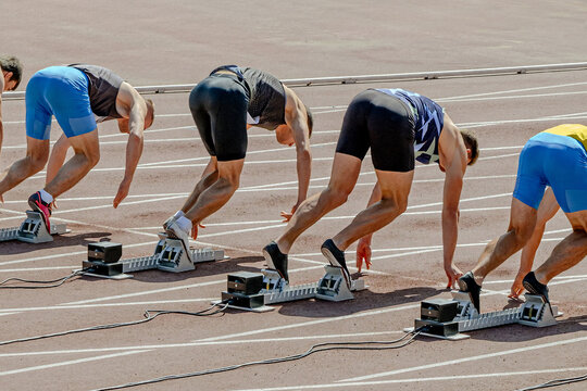 group sprinter runners in starting position ready, 100 - meter race in summer athletics championships
