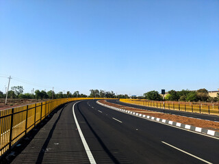 Naklejka premium the indian highway road with slight curve and blue sky
