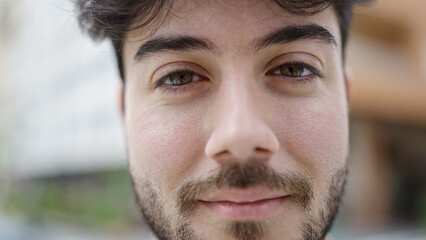 Obraz premium Young hispanic man standing with relaxed expression at street