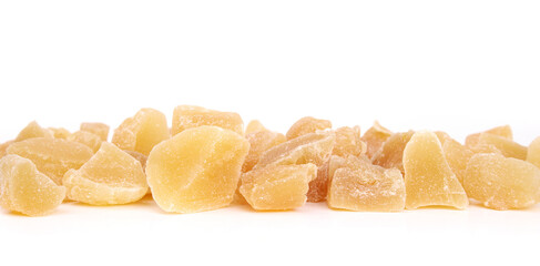 Candied ginger pieces in a row. Many yellow chunks of candied or crystallized ginger. Healthy snack for helping with digestive system, motion sickness and immunize system. Selective focus. Isolated.