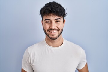 Hispanic man with beard standing over white background with a happy and cool smile on face. lucky person.