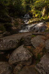 Obraz premium Amazing waterfall hidden deep in Jizera mountains, Czech Republic. Calm and peaceful place with water flowing in cascade river.