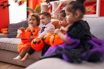 Fototapeta premium Group of kids wearing halloween costume holding pumpkin basket at home