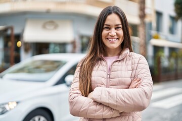 Young woman smiling confident standing with arms crossed gesture at street