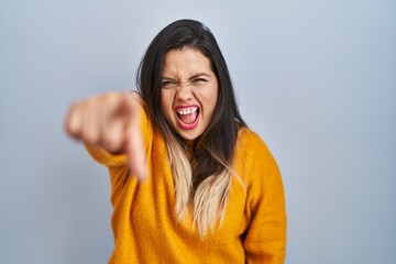 Young hispanic woman standing over isolated background pointing displeased and frustrated to the camera, angry and furious with you