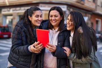 Three woman mother and daughters having video call at street