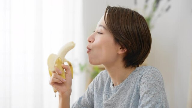 バナナを食べる若い女性　飲食イメージ