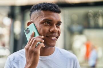 Young latin man smiling confident talking on the smartphone at street