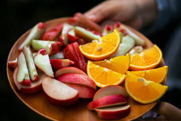 Close-up of Orange and Fresh rose apple slices on a plate
