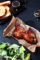Grilled chicken wings.Appetizer for beer. The grill wings are laid out on craft paper.