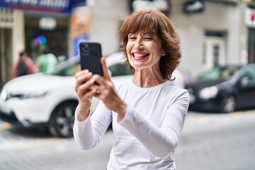 Middle age woman smiling confident having video call at street