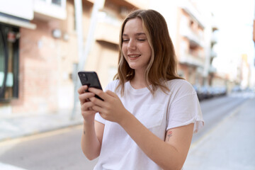 Young caucasian woman smiling confident using smartphone at street