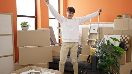 Young hispanic man smiling confident dancing at new home