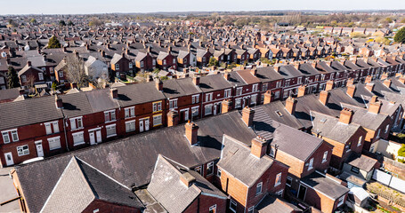 Aerial view above rows of back to back terraced houses on a large council estate