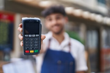Young arab man waiter holding data phone working at restaurant