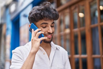 Young arab man smiling confident talking on the smartphone at street