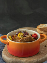 spicy vegan chili con carne with seitan and kamut, beans, chili, peppers with toasted baguette