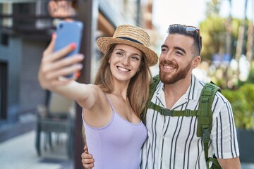 Fototapeta na wymiar Man and woman tourist couple smiling confident make selfie by smartphone at street