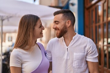 Man and woman couple smiling confident hugging each other at street