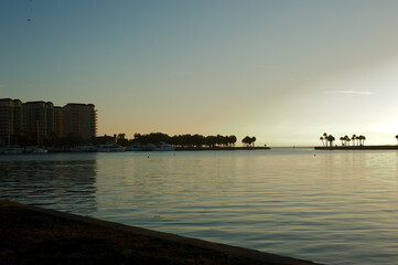 Naklejka premium Early Morning Sun Silhouette Water in Bay with Pier