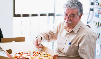 Latin grandfather happy to eat chicken, mushroom and vegetable pizza