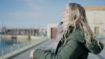 Young blonde woman breathing with closed eyes at seaside © Krakenimages.com