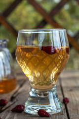 Red tea in a transparent cup on a wooden table, rosehip tea, rustic