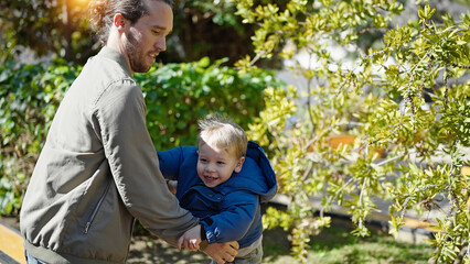 Father and son smiling confident at park