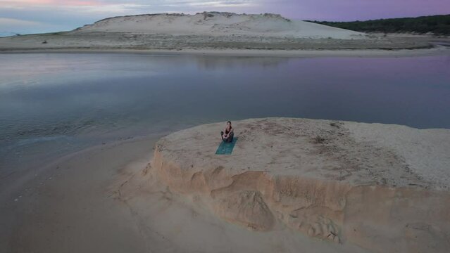 Relaxation and meditation during a yoga session by the sea at sunset