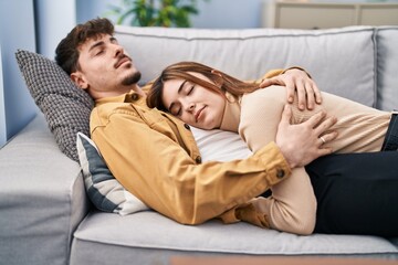 Mand and woman couple lying on sofa sleeping at home