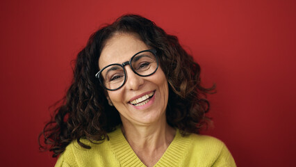 Obraz premium Middle age hispanic woman smiling confident standing over isolated red background