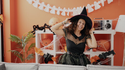 Middle age hispanic woman having halloween party dancing at home