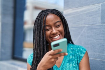 Fototapeta premium African american woman smiling confident talking on the smartphone at street