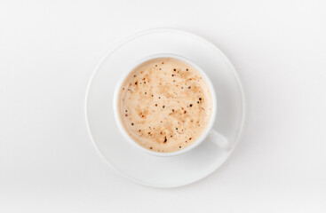 A white cup of coffee on a white background. Morning coffee with coffee foam. Top view.