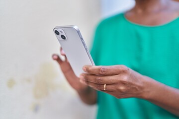 Middle age african american woman using smartphone at street