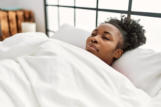 African american woman lying on bed sleeping at bedroom