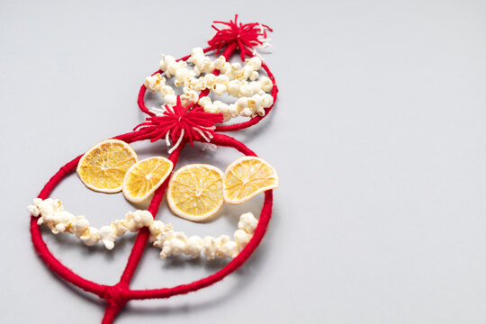 Survakane, Survaknitsa, Survachka, Surva On Gray Background. Bulgarian Traditional Christmas Cornel Tree Twig. Flat lay with Popcorn, Red White Threads, Dried Orange. World Tree. Horizontal,copyspace
