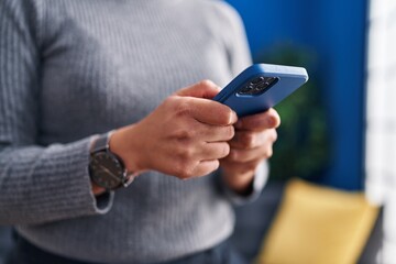 Young beautiful hispanic woman using smartphone at home