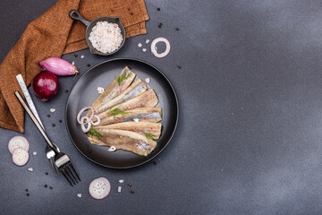 Fillet of pickled marinated sea herring fish with shallots and dill. Cutlery, vintage napkin