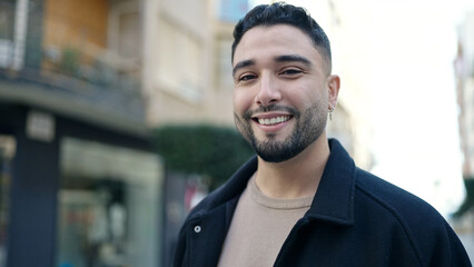 Young arab man smiling confident standing at street