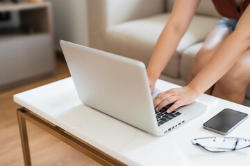 Close up Female typing on laptop keyboard working with digital data..